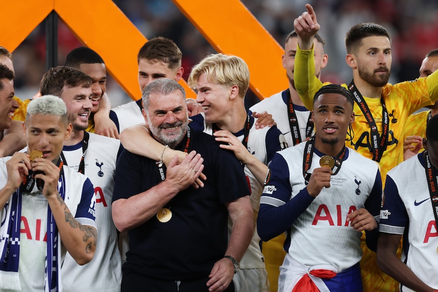 Ange Postecolgou is hugged by his players