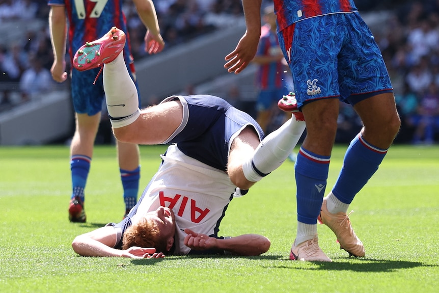 Tottenham Hotspur's Dejan Kulusevski rolling on the ground, lying on the back of his head, legs in the air, after falling down