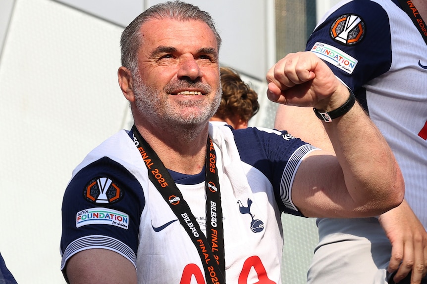Ange Postecoglou pumps his fist during Spurs' street parade.