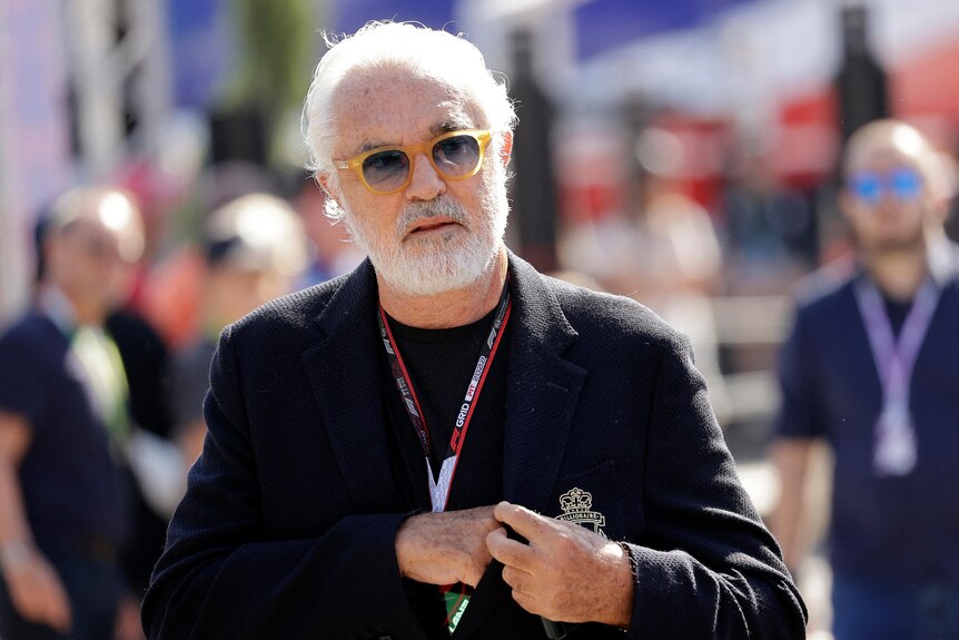 Former F1 team boss Flavio Briatore, walking on the grid at Monza before the race, wearing all black