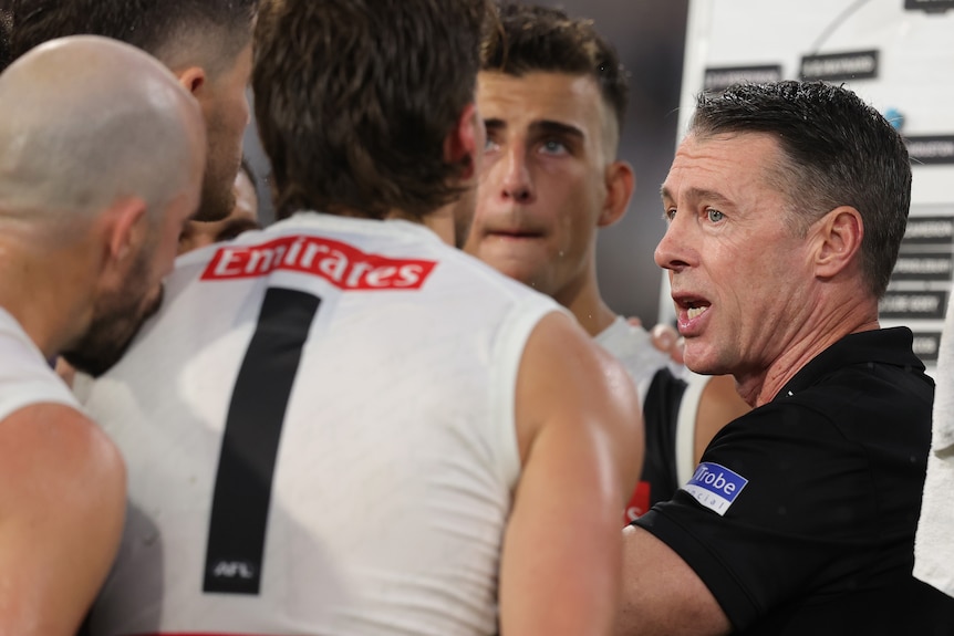 Craig McRae speaks to players in a huddle