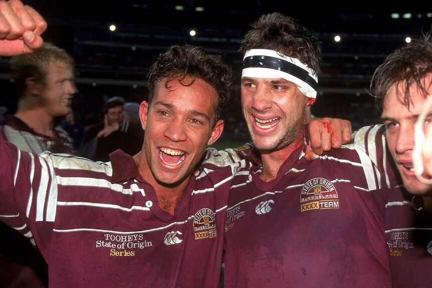 Two men celebrate winning a game of rugby league 
