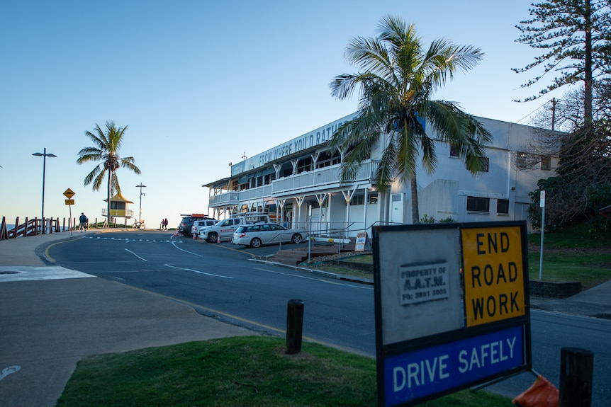 A Queenslander style building with a wooden wrap-around verandah.