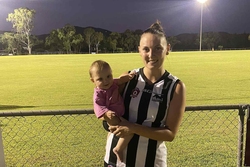 A mum holding her daughter after playing football.