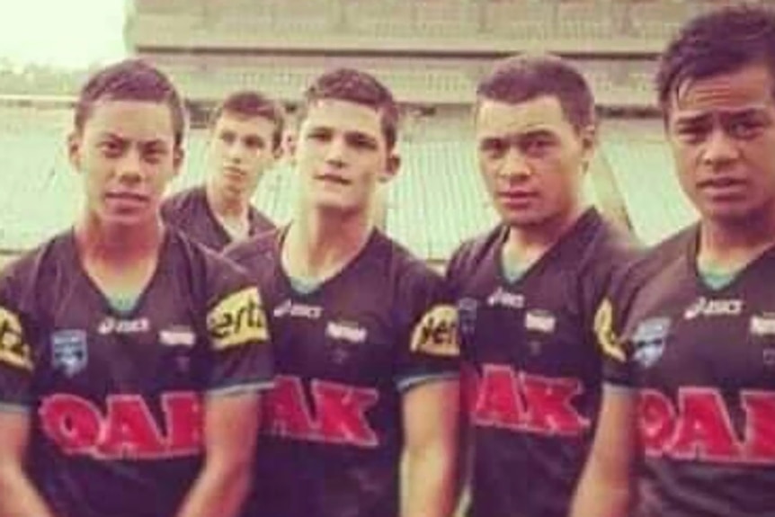 A group of boys pose for the camera after a rugby league match 