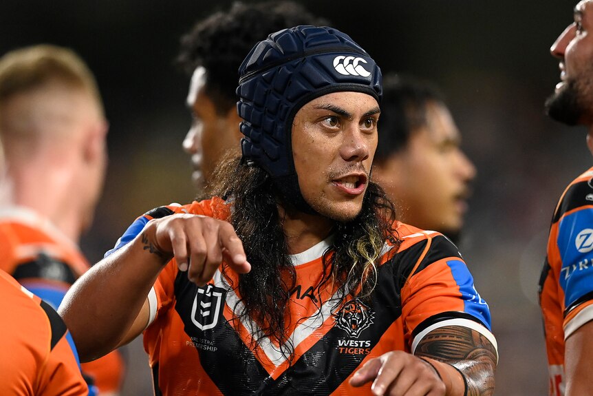 A man gestures to a teammate during a rugby league match 