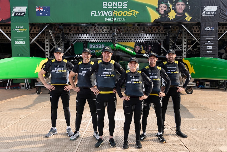 A team of people in front of a sailing base