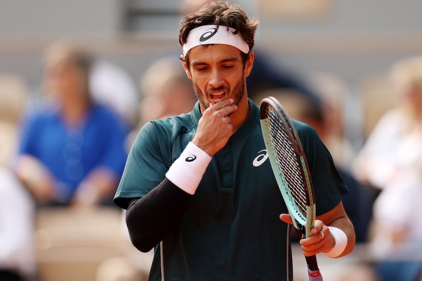  Lorenzo Musetti rubs his chin during a French Open match.