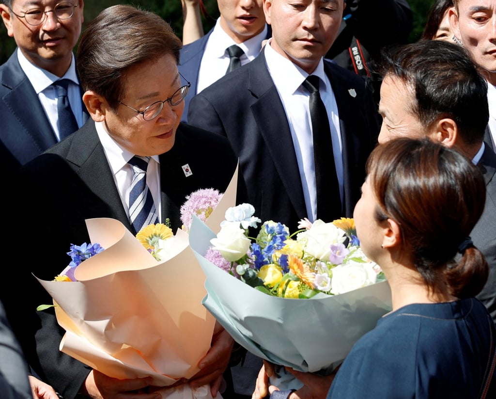 Supporters hand flowers to President Lee Jae-myung as he departs for the National Assembly to attend his inauguration ceremony on Wednesday. Photo: Reuters