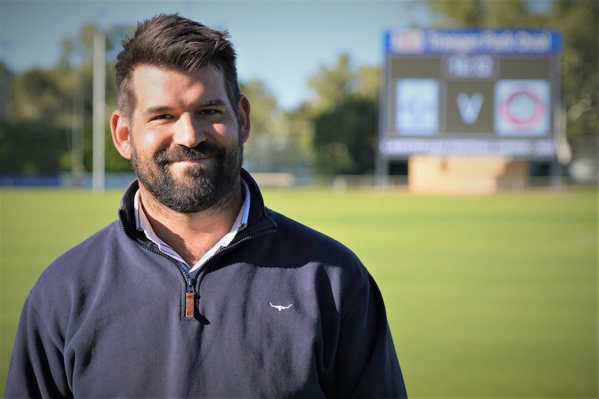 a man stands on a footy oval