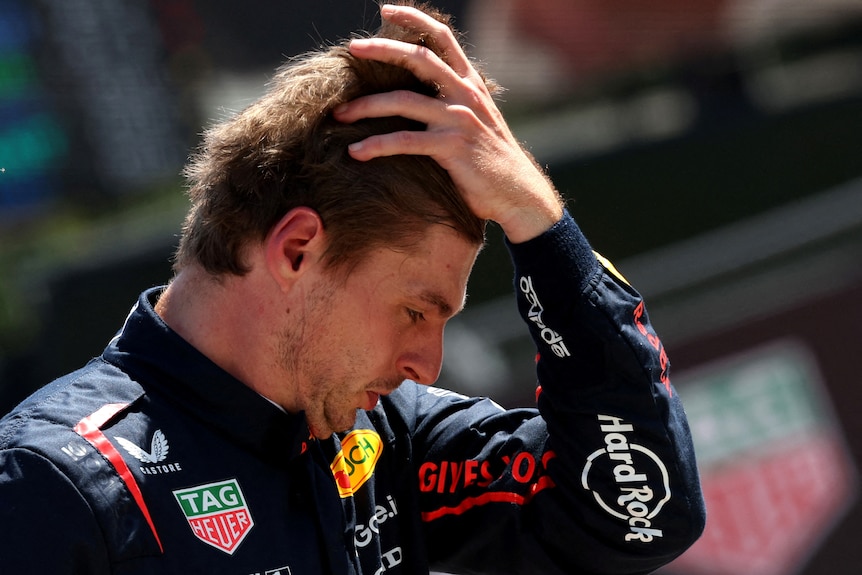 Red Bull's Max Verstappen looks dejected, holding his head in his left hand