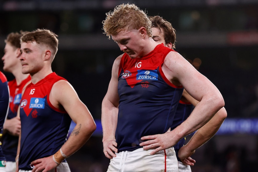Clayton Oliver walks off the field with his head down