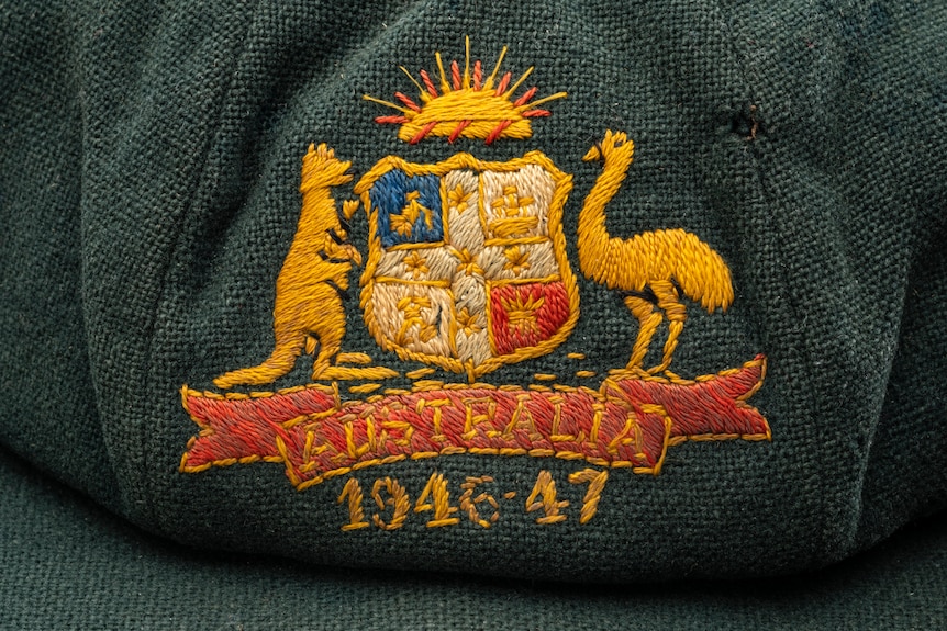 Close-up of the crest on a baggy green cricket cap with the years 1946-47 embroidered on the front.