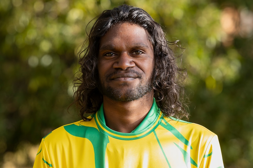 A profile shot of Lesley wearing a yellow and green jersey.