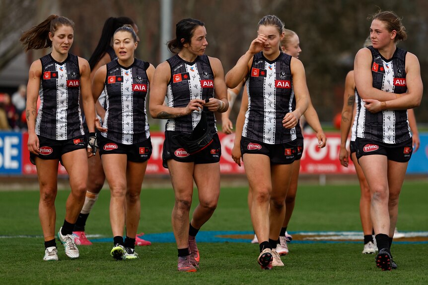 Collingwood AFLW players walking off the ground