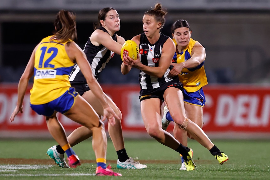 Ruby Schleicher of the Magpies runs with the ball.