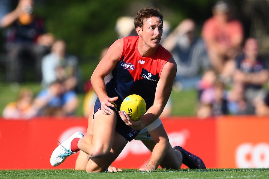 Mitch Brown handballs playing for Melbourne