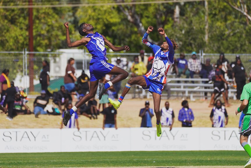 Two players leaping into the air in an attempt to catch the ball.