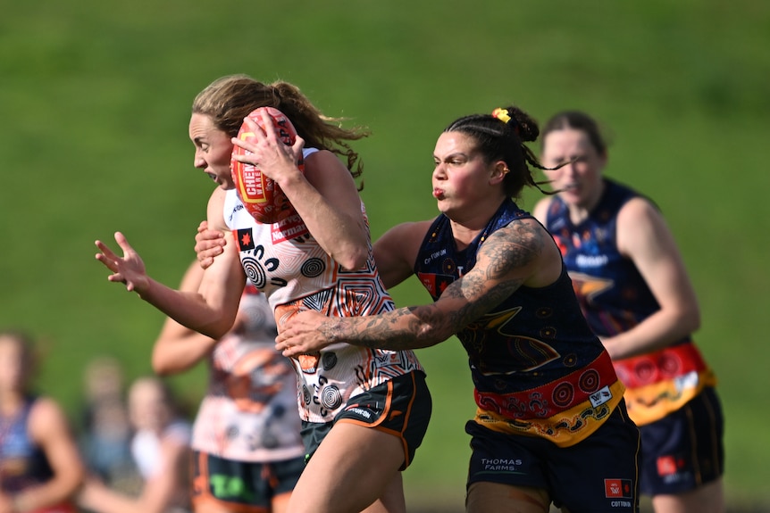 Anne Hatchard of the Crows tackles Tarni Evans of the Giants