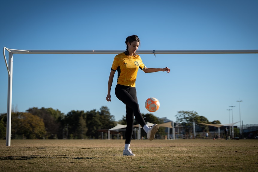Woman on a soccer field with a ball.