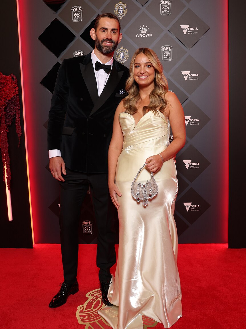 Brodie Grundy of the Swans and partner Rachel Wertheim in a white shimmery gown 