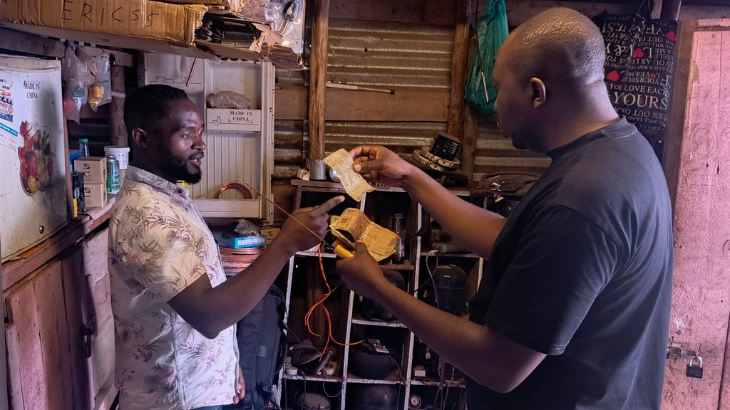 A customer pays for a service with perforated notes in Bukavu, DR Congo. Photo: AP A customer pays for a service with perforated notes in Bukavu, DR Congo. Photo: AP