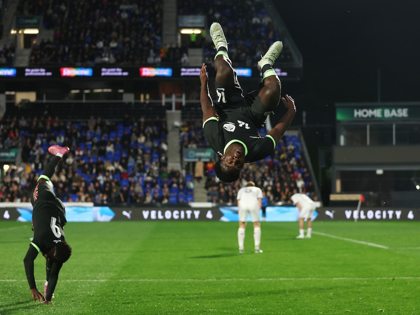 Australian soccer player Nestory Irankunda celebrates with a backflip after a goal.