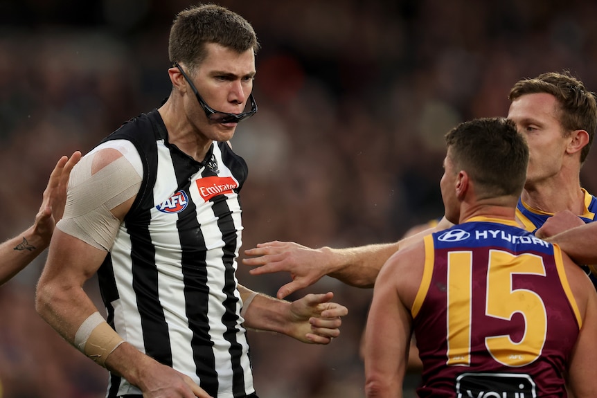 The eyewear of Mason Cox of the Magpies is knocked off his head by Dayne Zorko of the Lions.
