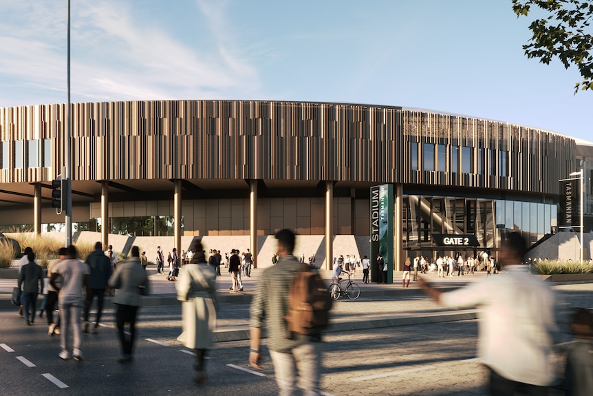 Pedestrians walks across a road out the front of a large stadium.