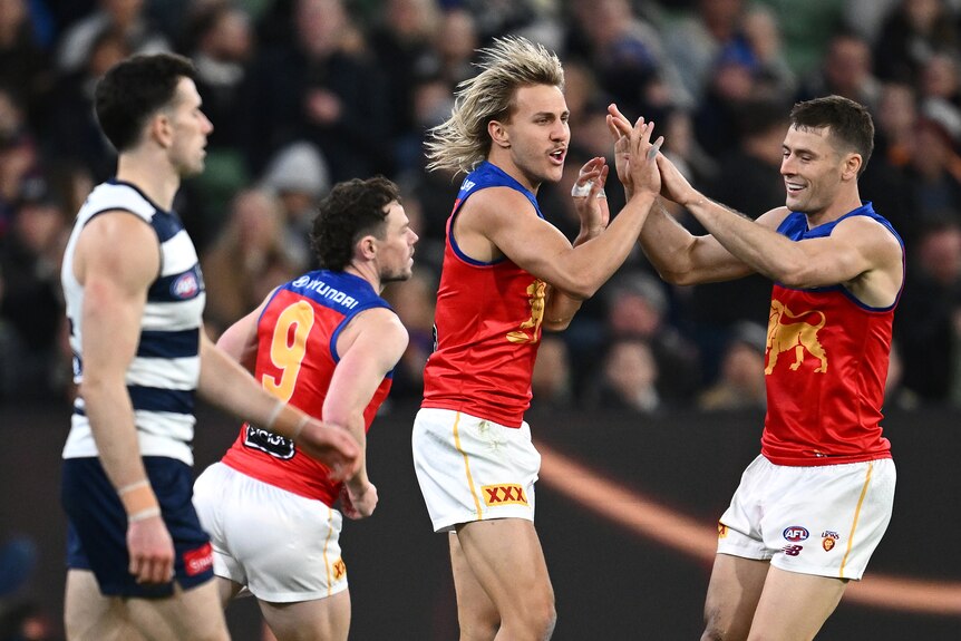 The Brisbane Lions celebrating after scoring a goal.