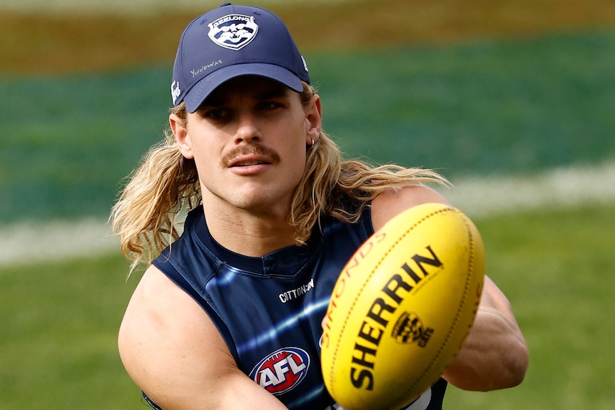 Geelong Cats player Bailey Smith handpasses a football at AFL training.