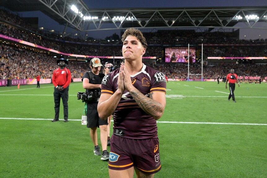 Reece Walsh directs prayer hands at the Lang Park crowd.