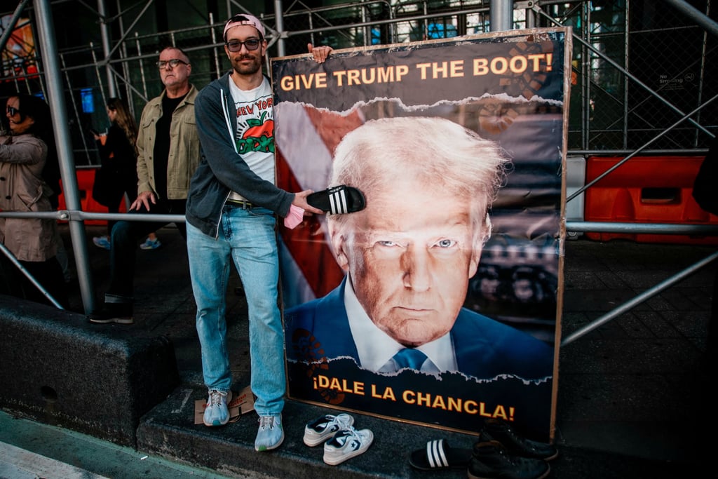 A person hits with a sandal an image of US President Donald Trump, during a “No Kings” protest against Trump’s policies, in Times Square in New York City on Saturday. Photo: Reuters