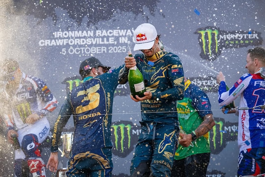 Two young men spraying champagne on the victory podium.