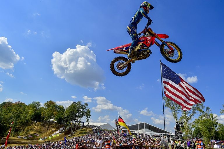 A motocross rider flying through the air after hitting a jump.