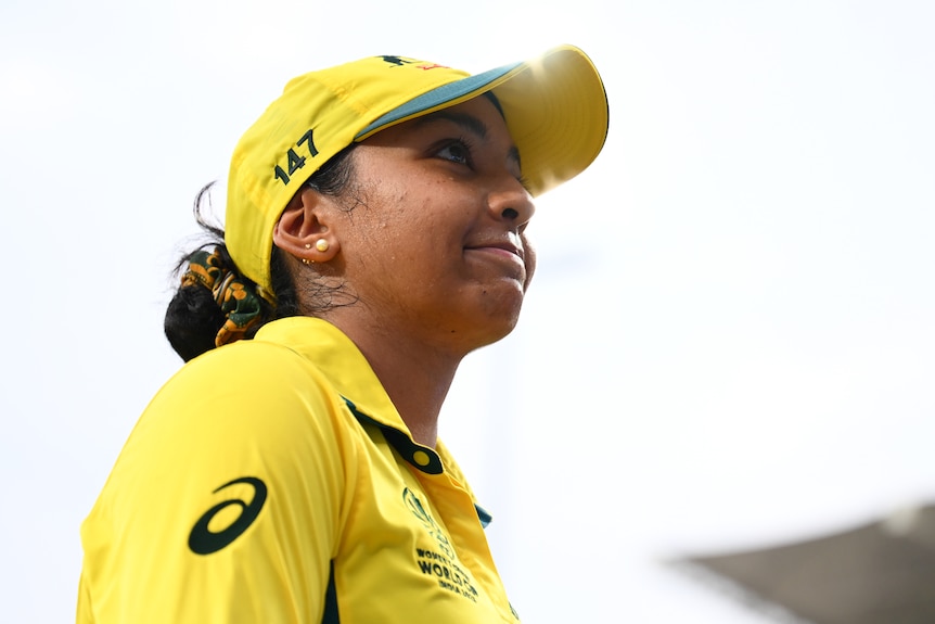 Alana King smiles and looks upwards in her ODI kit