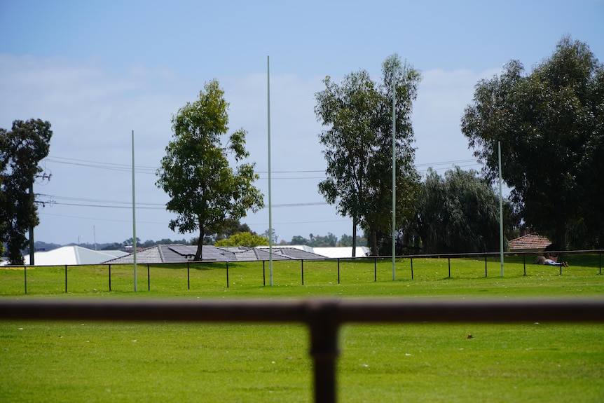 A suburban park with Australian rules football goals visible. 