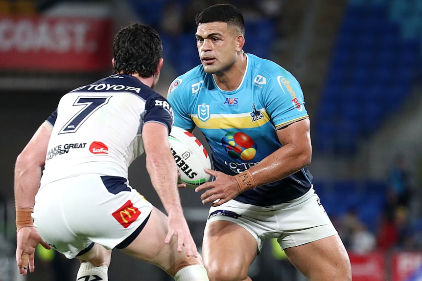 NRL player David Fifita, with ball in hand, approaches a defender