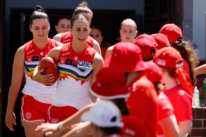 Sydney players run out before the AFLW Round 9 match.
