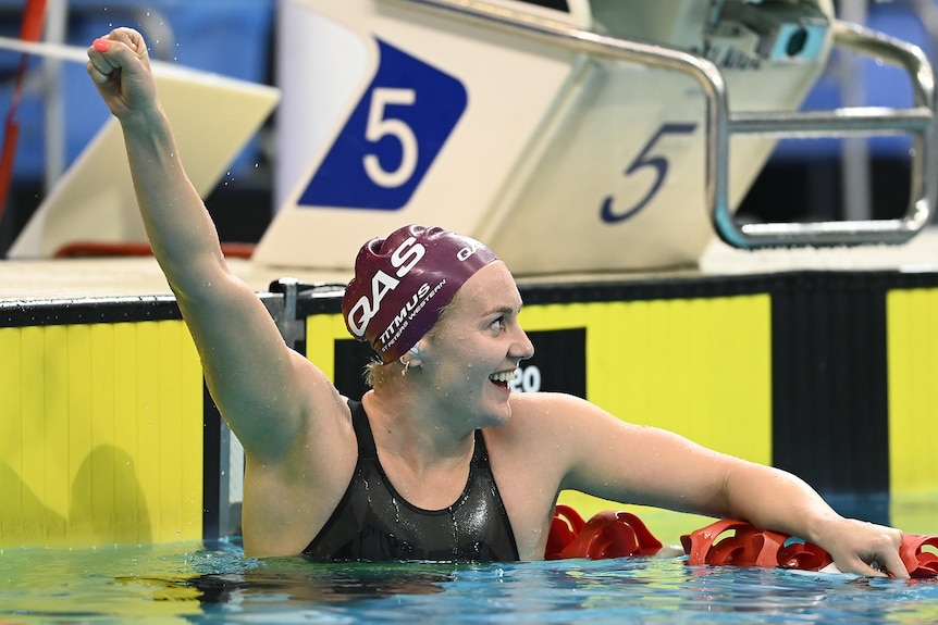 Ariarne Titmus holds up her hand and looks to her left