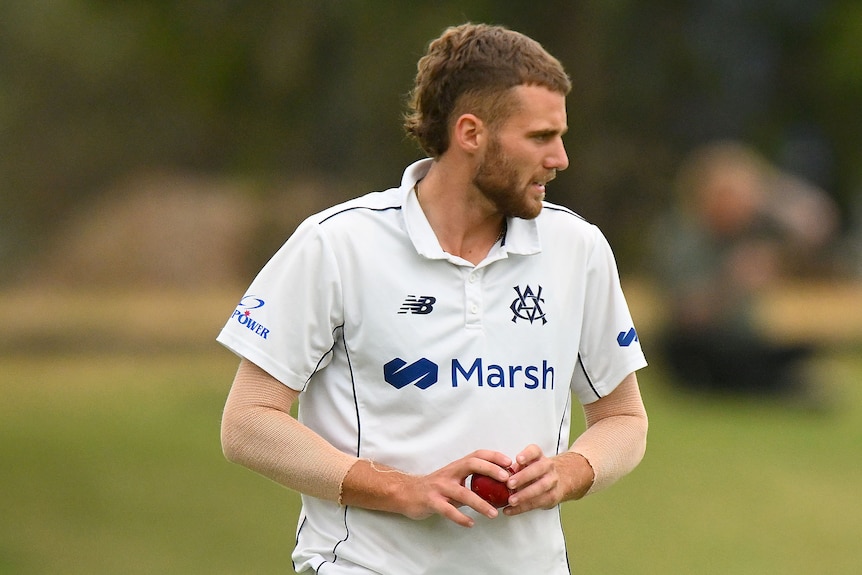 Male fast bowler holding the ball, about to begin his run-up to the crease