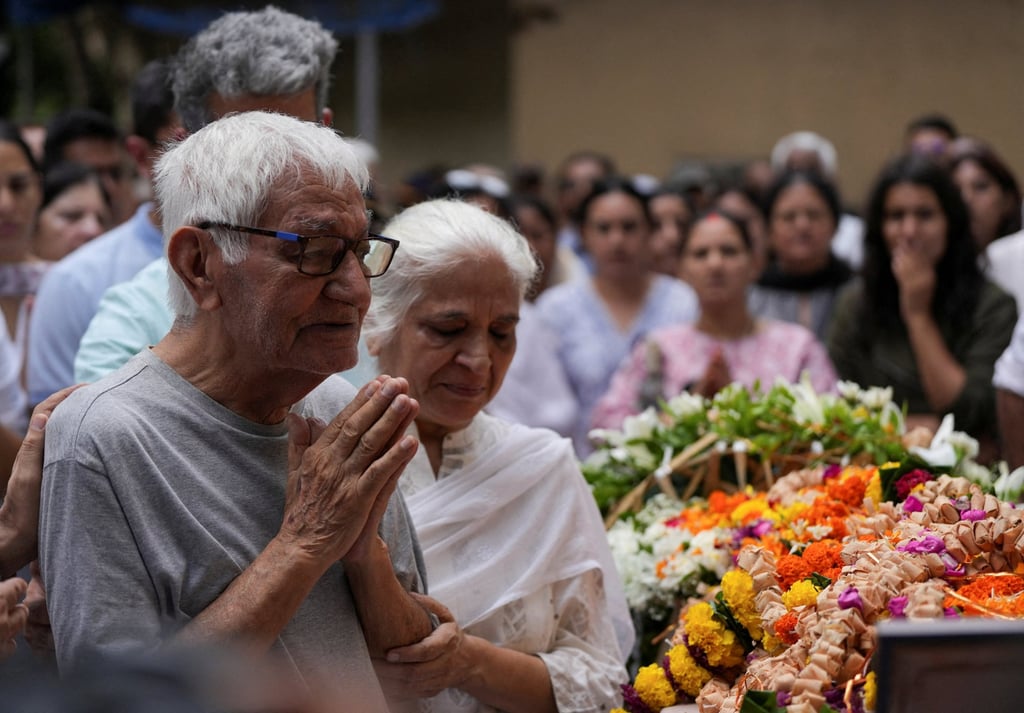 Pushkar Raj Sabharwal, the father of a pilot who died when an Air India aircraft crashed during take-off from an airport, offers prayers as he stands next to the body of his son in Mumbai, India in June. Photo: Reuters