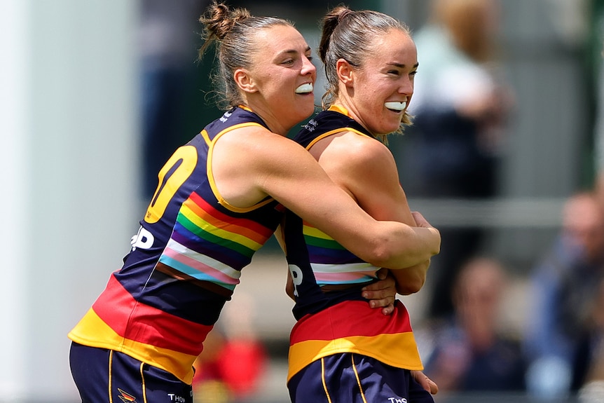 Ebony Marinoff and Madison Newman embrace as they celebrate an AFLW goal for the Adelaide Crows.