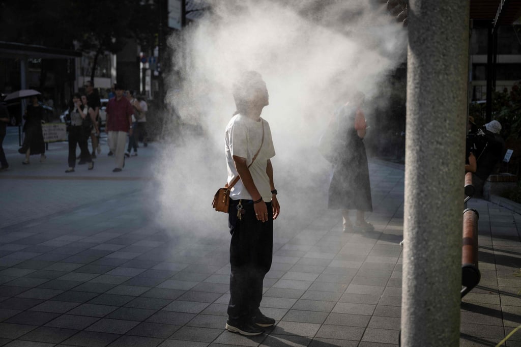 A man standing under a water misting system to cool down on a hot day in Tokyo. Photo: AFP A man standing under a water misting system to cool down on a hot day in Tokyo. Photo: AFP