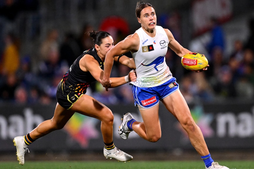 Jasmine Garner of the Kangaroos is tackled by Monique Conti of the Tigers.