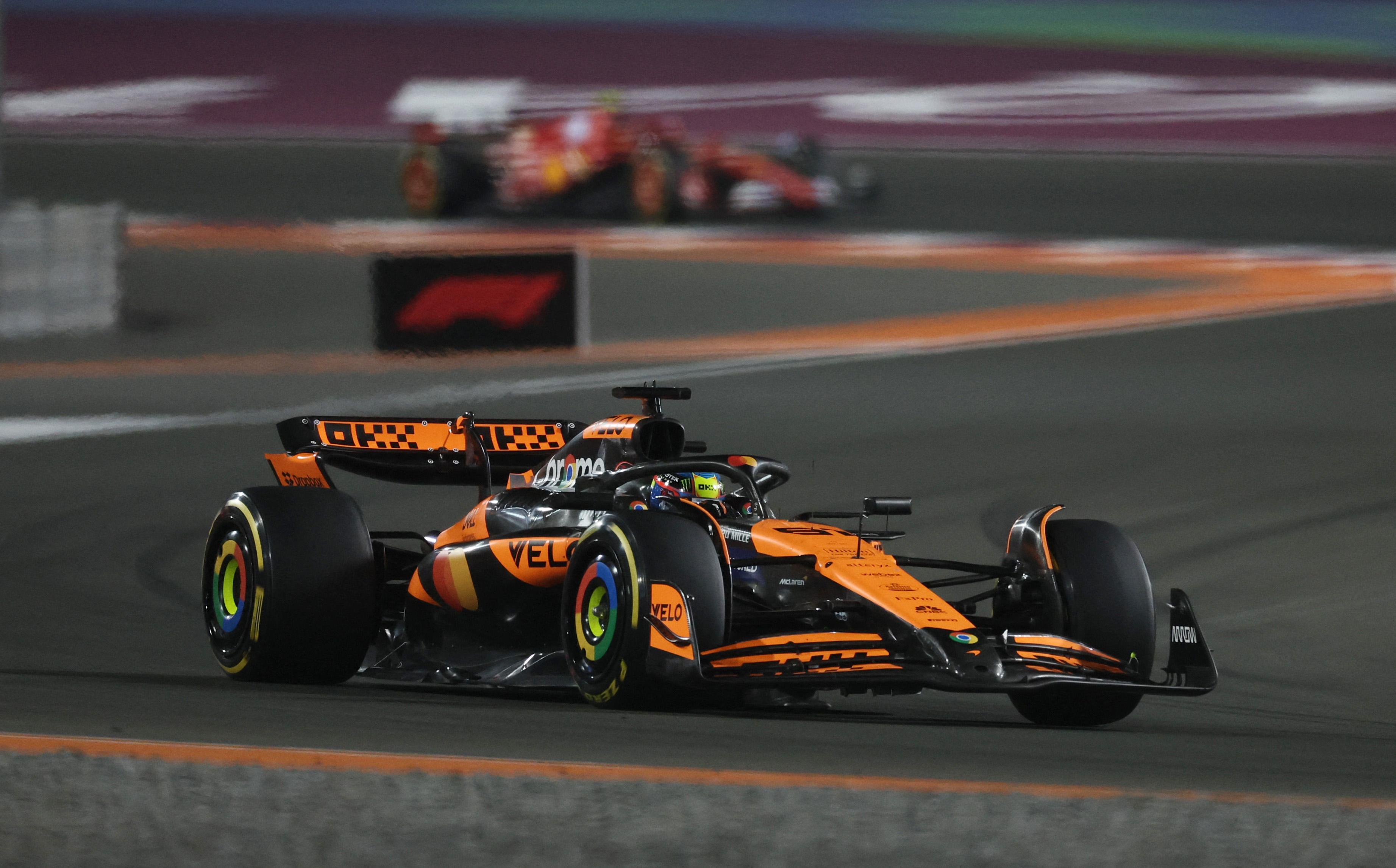 Oscar Piastri driving his McLaren F1 car during a night race in Qatar around a left-hand corner