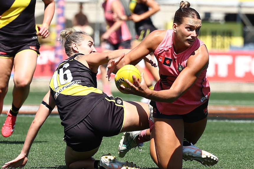 Havana Harris of the Suns is tackled by Laura McClelland of the Tigers.