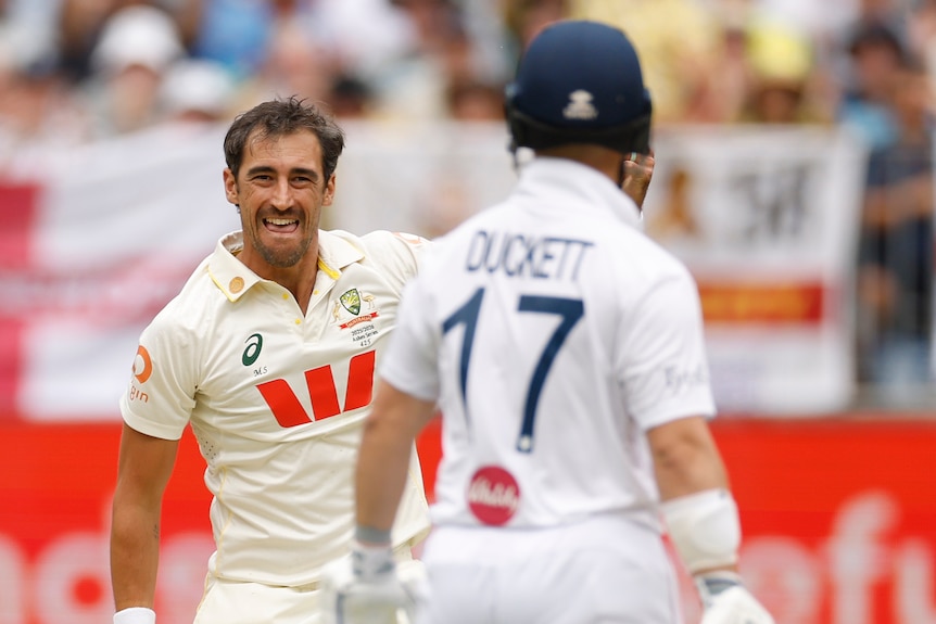 Mitchell Starc celebrates a catch while looking at Ben Duckett.