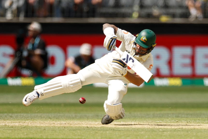 Jake Weatherald falls to the pitch while batting in a cricket Test.