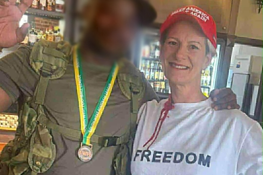 A woman in a red cap and white t-short with fake blood on her neck. 